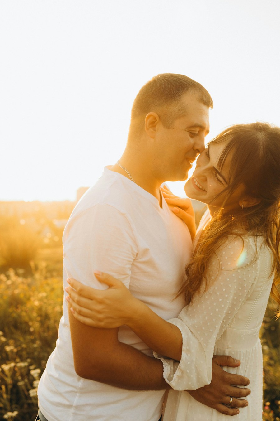 Pareja sonriente une sus frentes con ternura