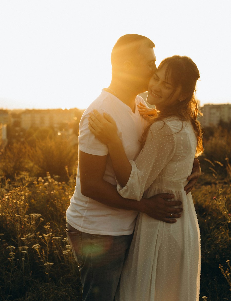 Dos personas comparten un beso al atardecer